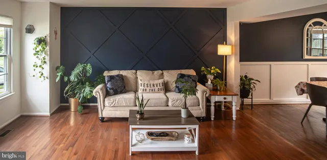 a living room with furniture a wooden floor and a flat screen tv