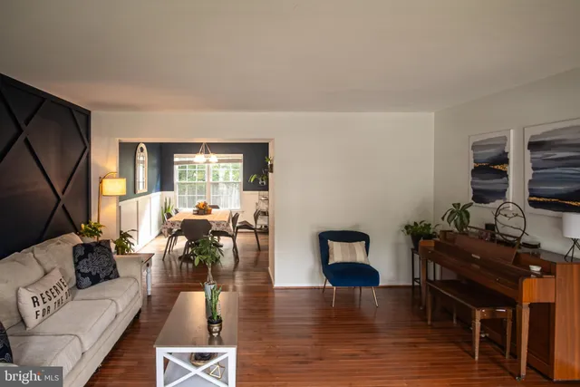 a living room with furniture flat screen tv and wooden floor