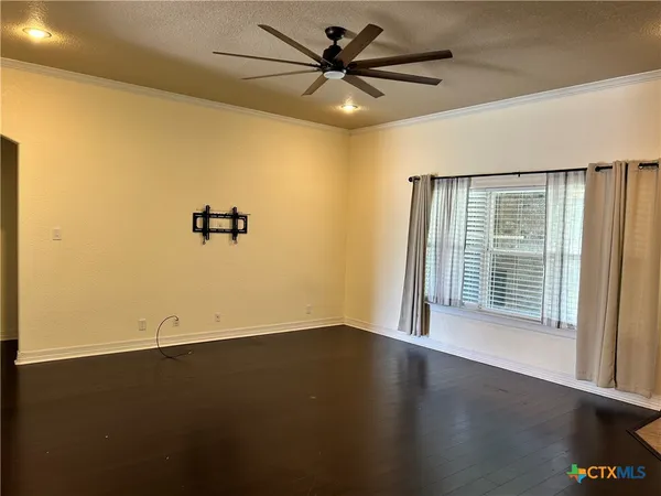 a view of a livingroom with a ceiling fan and hardwood floor