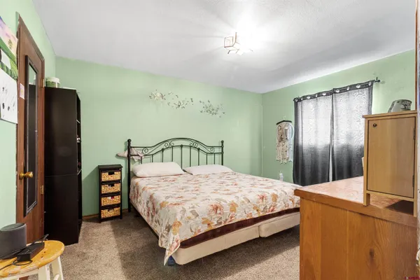 a view of a hallway with a bedroom and front door
