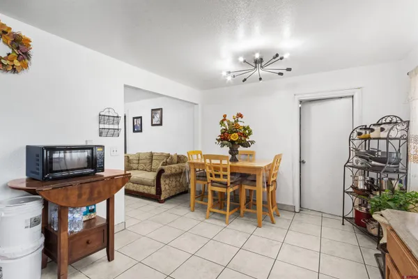 a dining room with furniture and chandelier fan