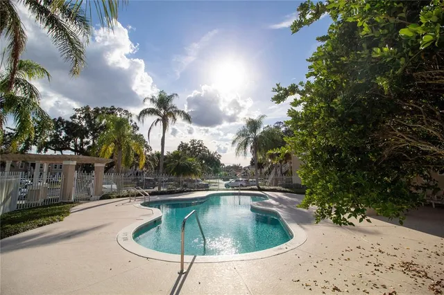 a swimming pool with outdoor seating and plants