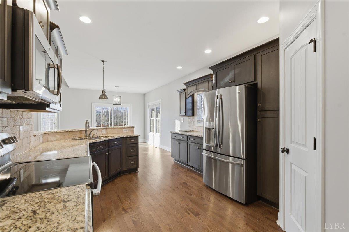 509 Cornerstone Street Lynchburg, VA 24502 - Photo 20 of 56 a kitchen with stainless steel appliances granite countertop a refrigerator a sink dishwasher a stove and a microwave oven with wooden floor