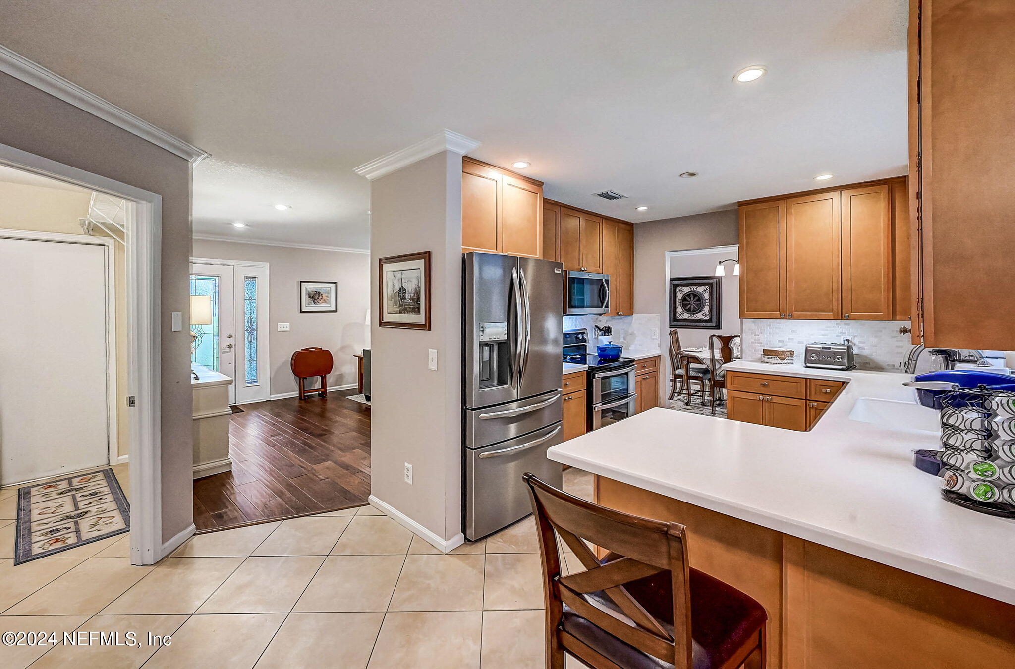 1130 Linwood Loop St. Johns, FL 32259 - Photo 11 of 34 a kitchen with stainless steel appliances a refrigerator a stove a sink dishwasher and white cabinets with wooden floor