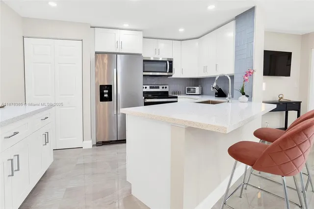 a kitchen with stainless steel appliances a refrigerator sink and microwave