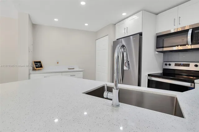 a kitchen with stainless steel appliances a refrigerator and a stove top oven