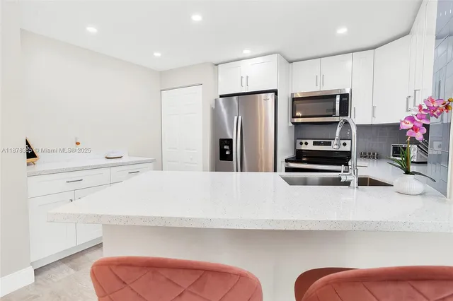 a kitchen with white cabinets and stainless steel appliances