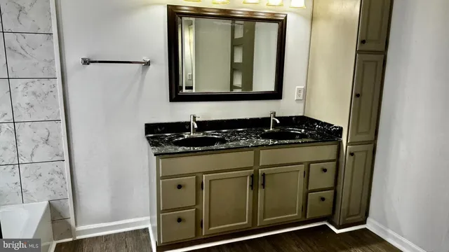 a bathroom with a granite countertop sink and a mirror