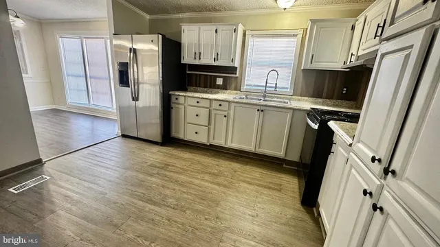 a kitchen with stainless steel appliances a refrigerator sink and microwave