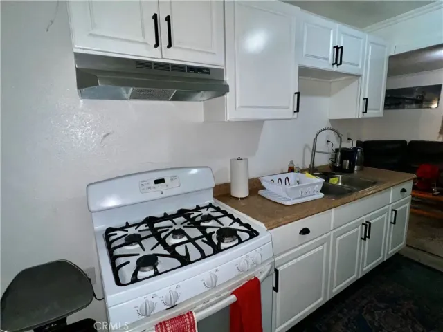 a kitchen with sink a stove and cabinets