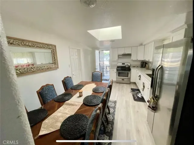 a view of a dining room with furniture a rug and wooden floor