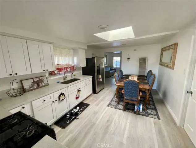 a large white kitchen with sink and chairs