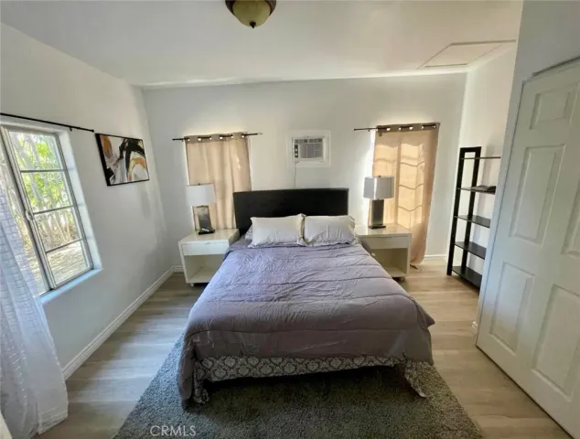 a bedroom with a bed and wooden floor