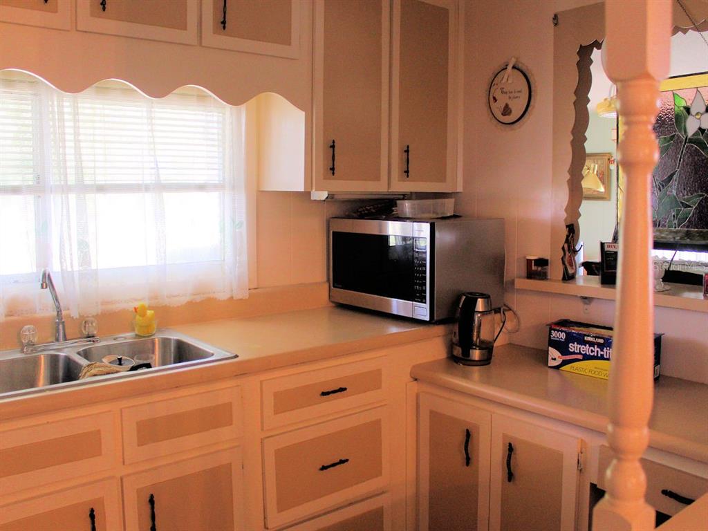55 Thatch Palm Street West Largo, FL 33770 - Photo 2 of 14 a kitchen with cabinets a window and a sink