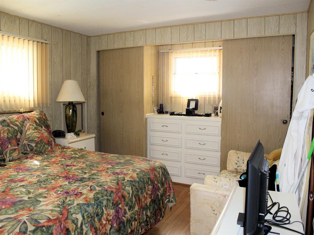 55 Thatch Palm Street West Largo, FL 33770 - Photo 10 of 14 a bedroom with a bed and a flat tv screen on the dresser