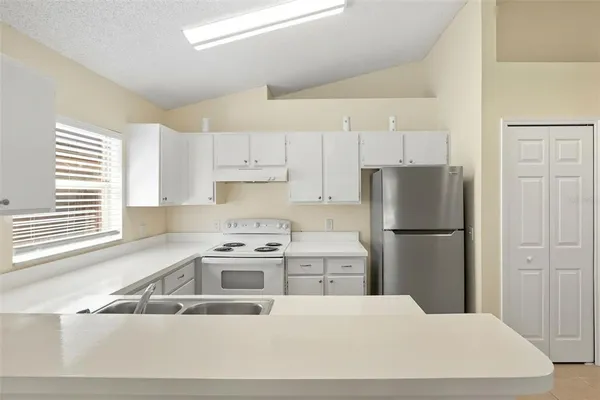 a kitchen with a refrigerator a stove a sink and a cabinets