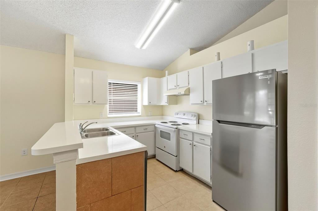 1148 Golden Gate Avenue Orlando, FL 32808 - Photo 13 of 26 a kitchen with a refrigerator a stove a sink dishwasher and a refrigerator