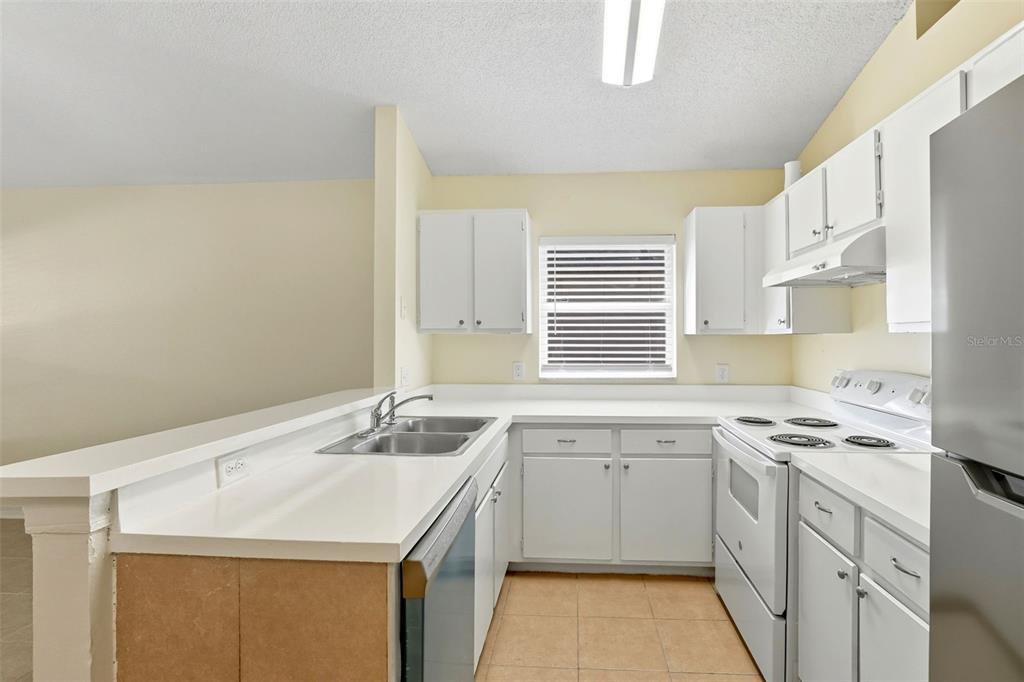 1148 Golden Gate Avenue Orlando, FL 32808 - Photo 14 of 26 a kitchen with a sink stove and cabinets