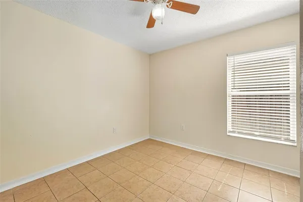 an empty room with closet and a chandelier fan