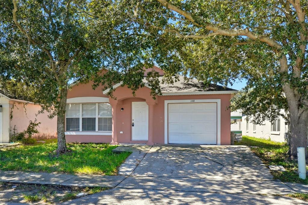 1148 Golden Gate Avenue Orlando, FL 32808 - Photo 3 of 26 a house with a tree in front of it