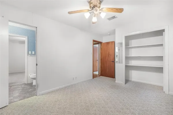 a view of an empty room with a ceiling fan