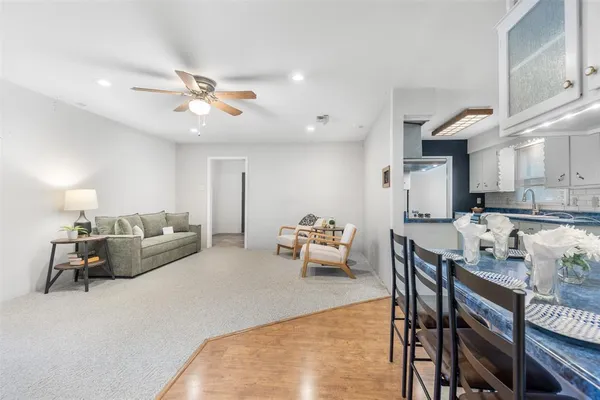 a living room with furniture kitchen view and a chandelier