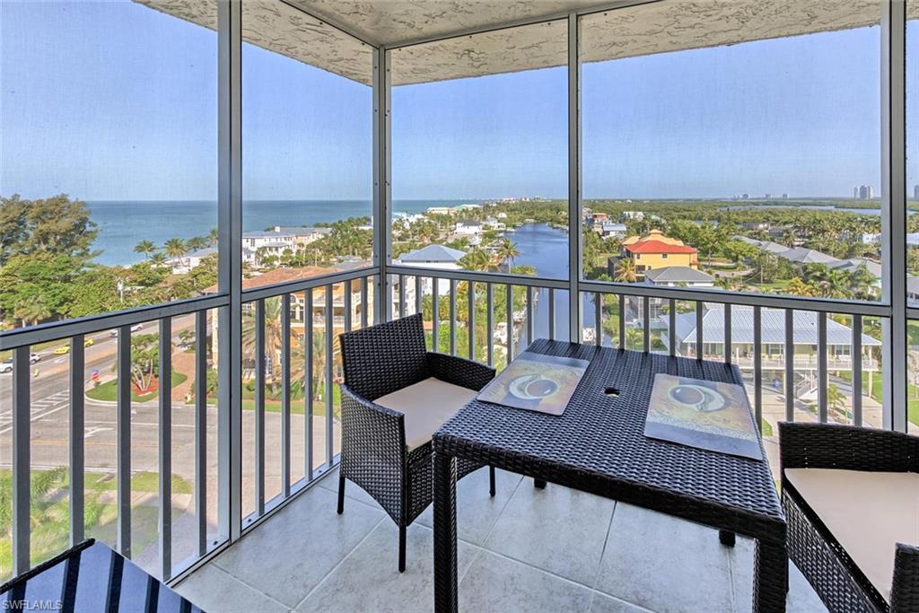 5900 Bonita Beach Road Southwest, Unit 1004 Bonita Springs, FL 34134 - Photo 15 of 27 a view of a city from a balcony with furniture