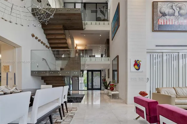 a living room with furniture and floor to ceiling windows