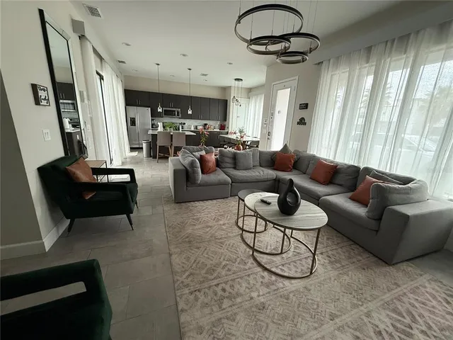a living room with furniture and a chandelier