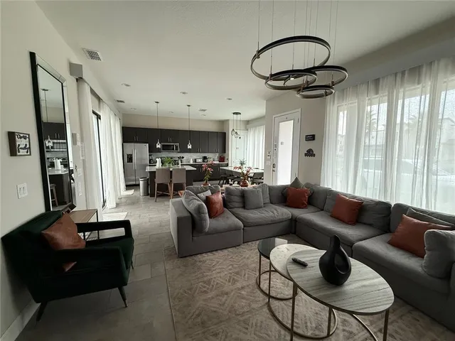 a living room with furniture and a chandelier