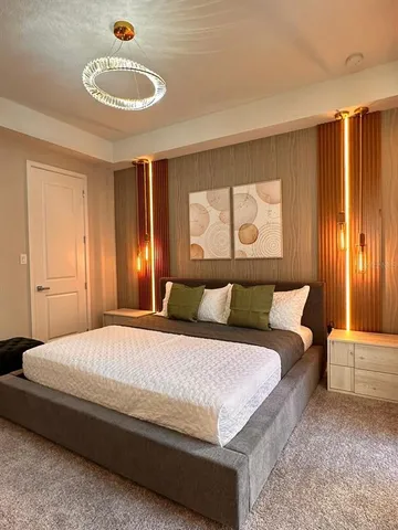 a bedroom with a large bed and a chandelier