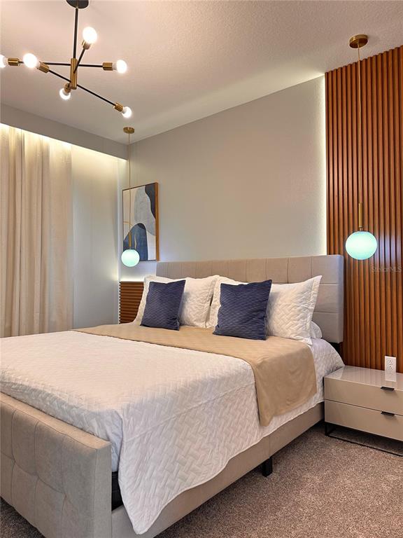 304 Villa Domani Court Davenport, FL 33896 - Photo 20 of 37 a bedroom with a bed and a chandelier