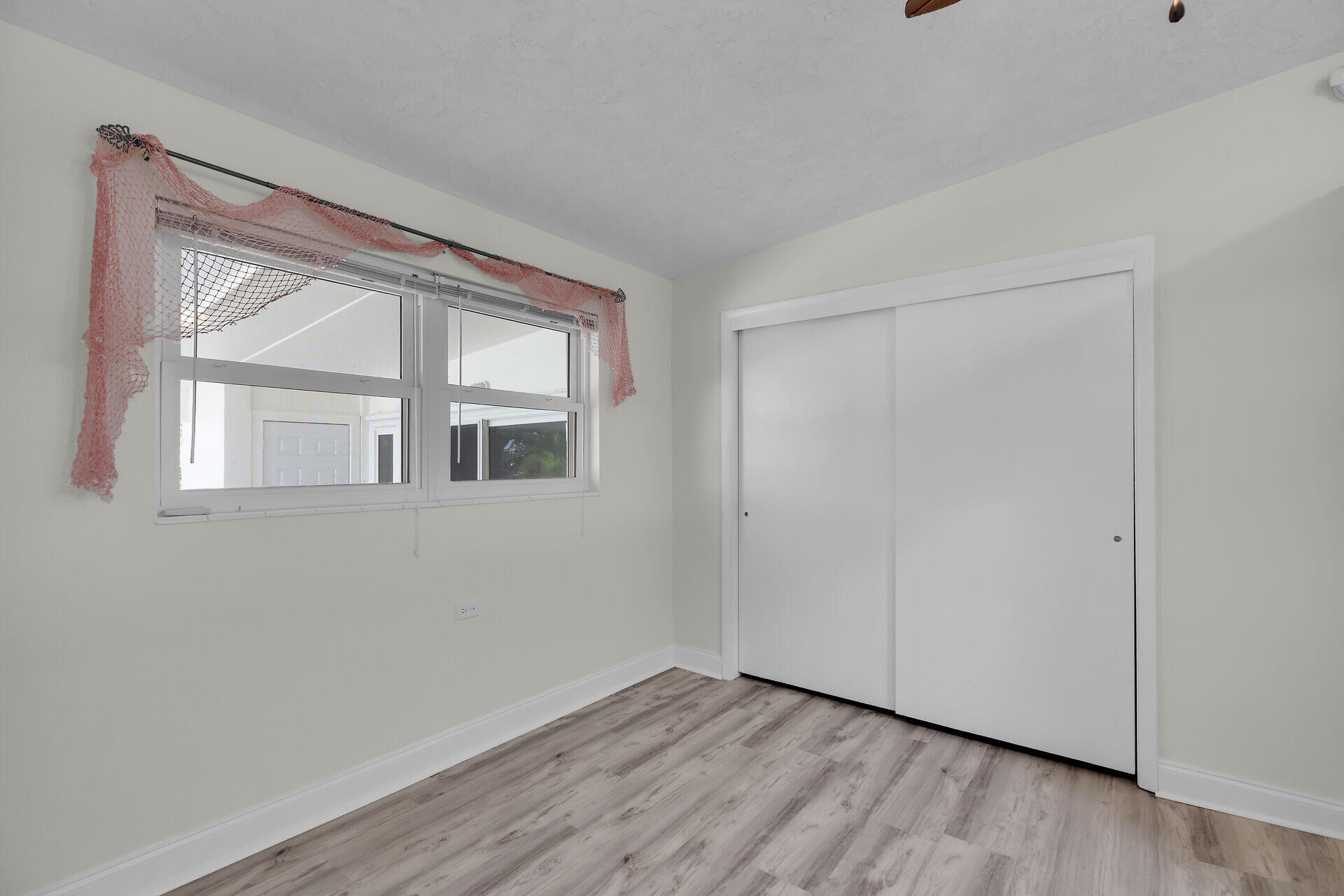 750 9th Street Key Colony Beach, FL 33051 - Photo 24 of 30 a view of an empty room with wooden floor and a window