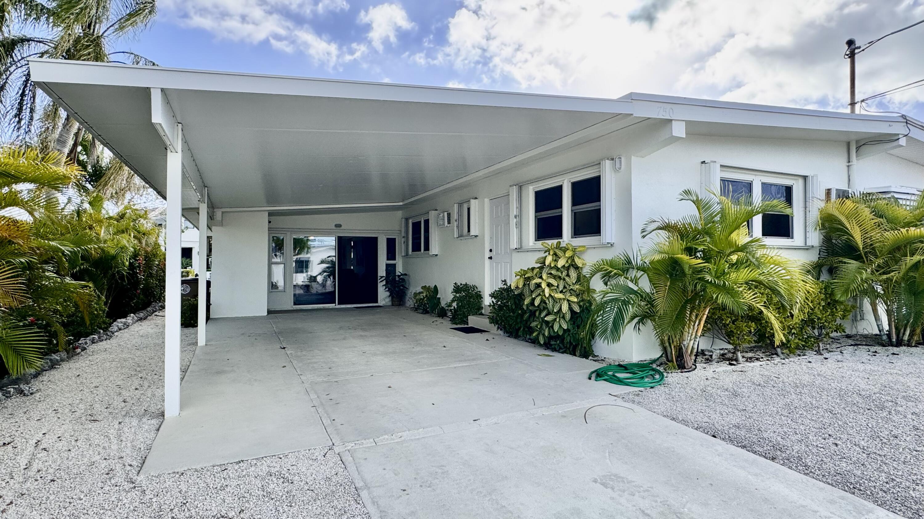 750 9th Street Key Colony Beach, FL 33051 - Photo 30 of 30 a view of a house with potted plants and a garage