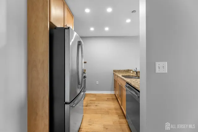 a kitchen with stainless steel appliances granite countertop a refrigerator and a stove