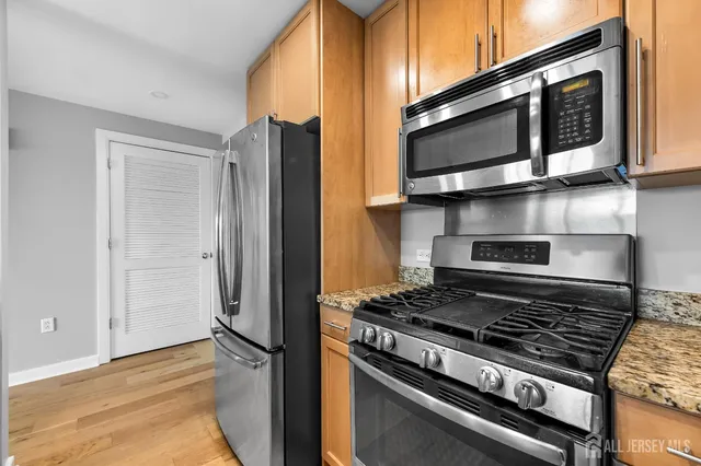 a kitchen with stainless steel appliances granite countertop a stove and a microwave
