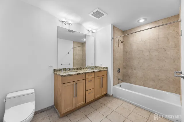 a bathroom with a granite countertop bathtub shower sink and vanity