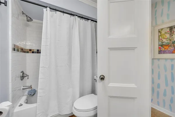 a bathroom with a sink a toilet and shower curtain