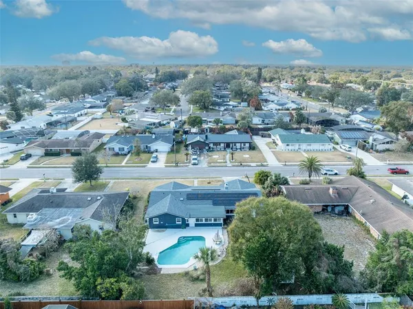 an aerial view of residential houses with outdoor space and parking
