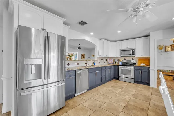 a kitchen with stainless steel appliances granite countertop a refrigerator sink and cabinets