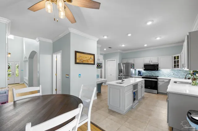 a kitchen with stainless steel appliances granite countertop a sink stove refrigerator and cabinets