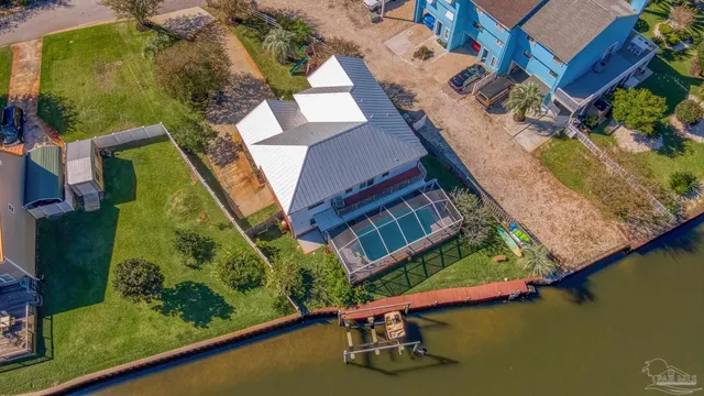 an aerial view of a house with a garden and lake view