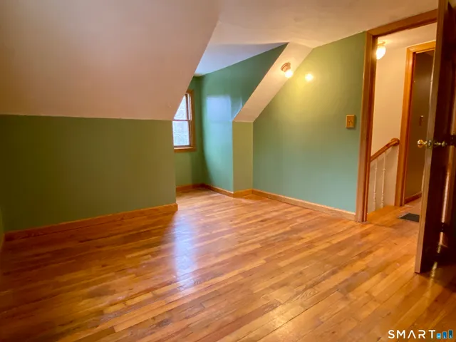 a view of a big room with wooden floor and windows