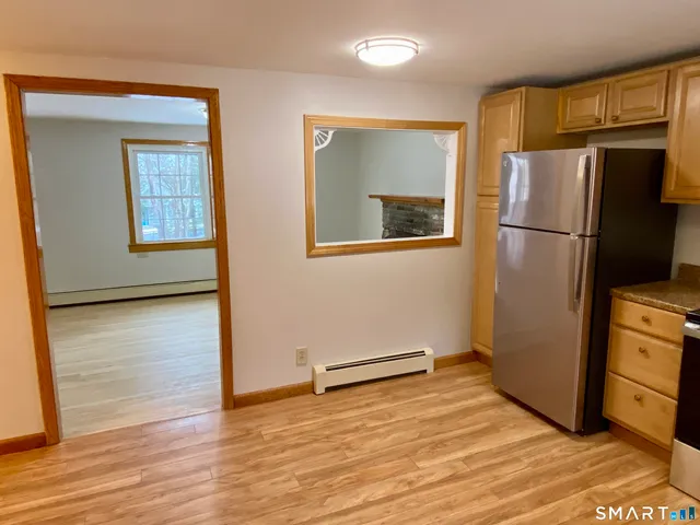 a view of a kitchen with wooden floor and a refrigerator