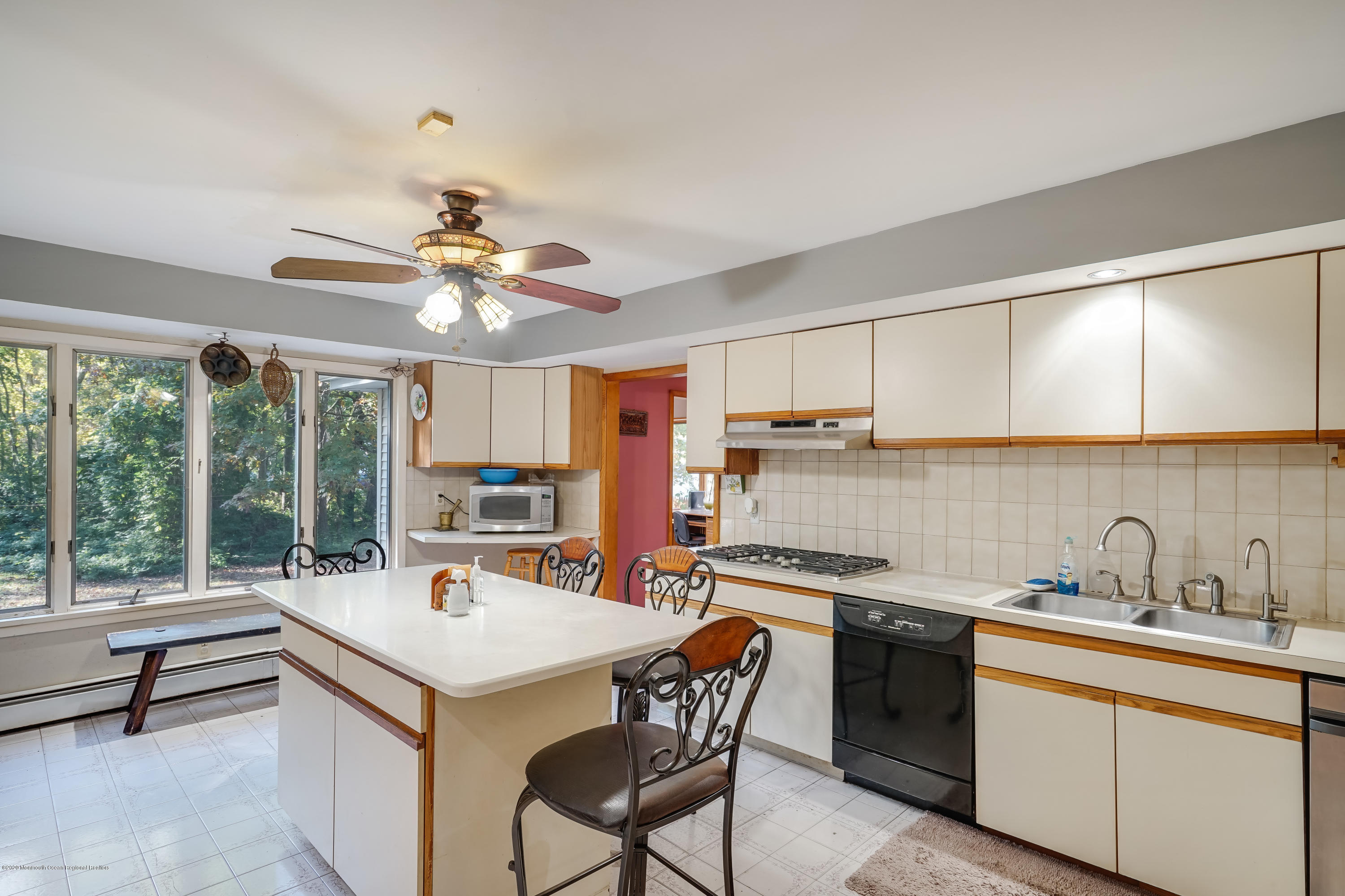 43 Korman Road Bayville, NJ 08721 - Photo 11 of 47 a kitchen with a stove a sink dishwasher a kitchen island with a dining table and chairs
