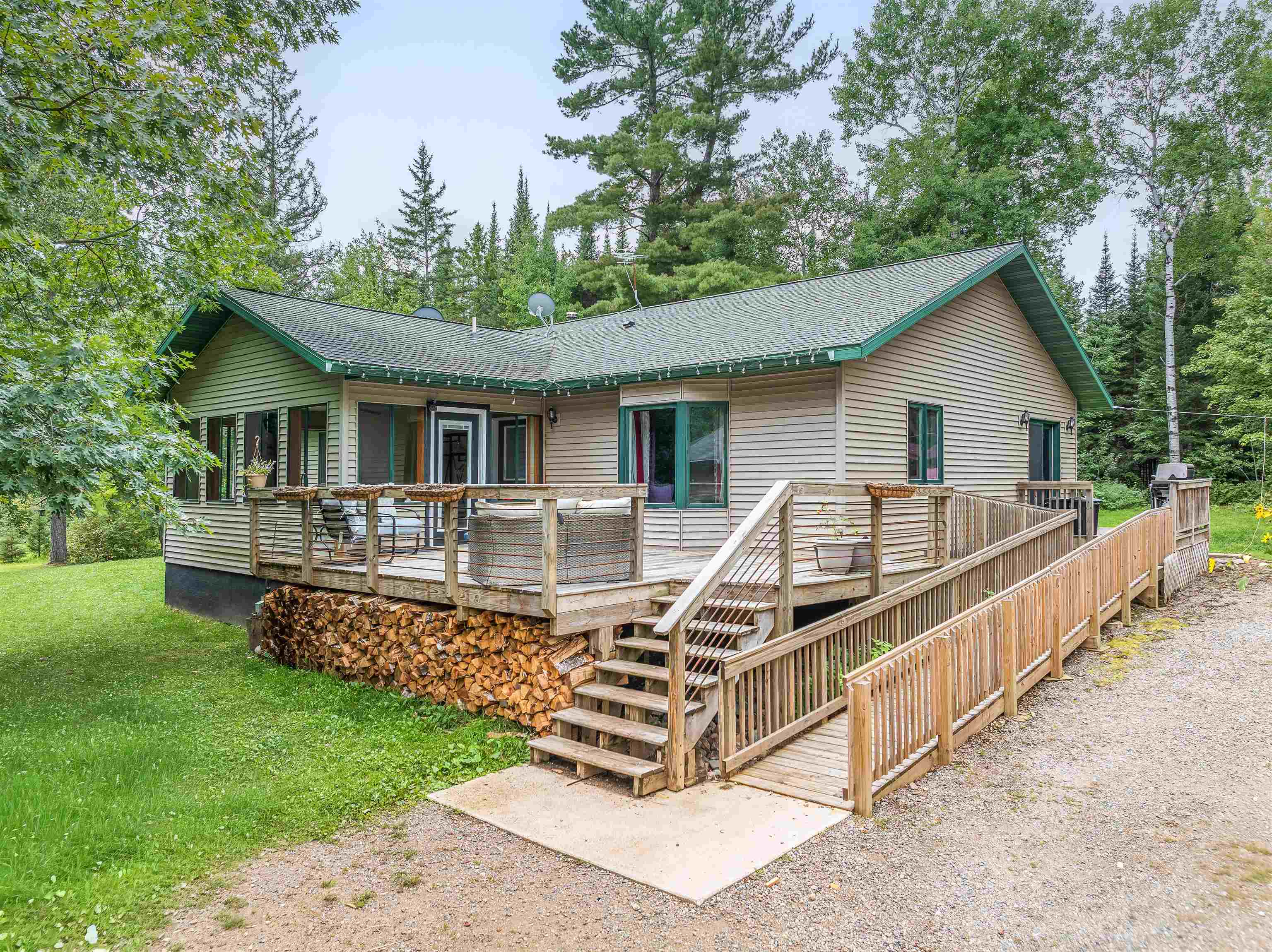 7345 Rahkola Road Embarrass, MN 55732 - Photo 20 of 57 Rear view of house with a deck, roof with shingles, stairway, and a yard