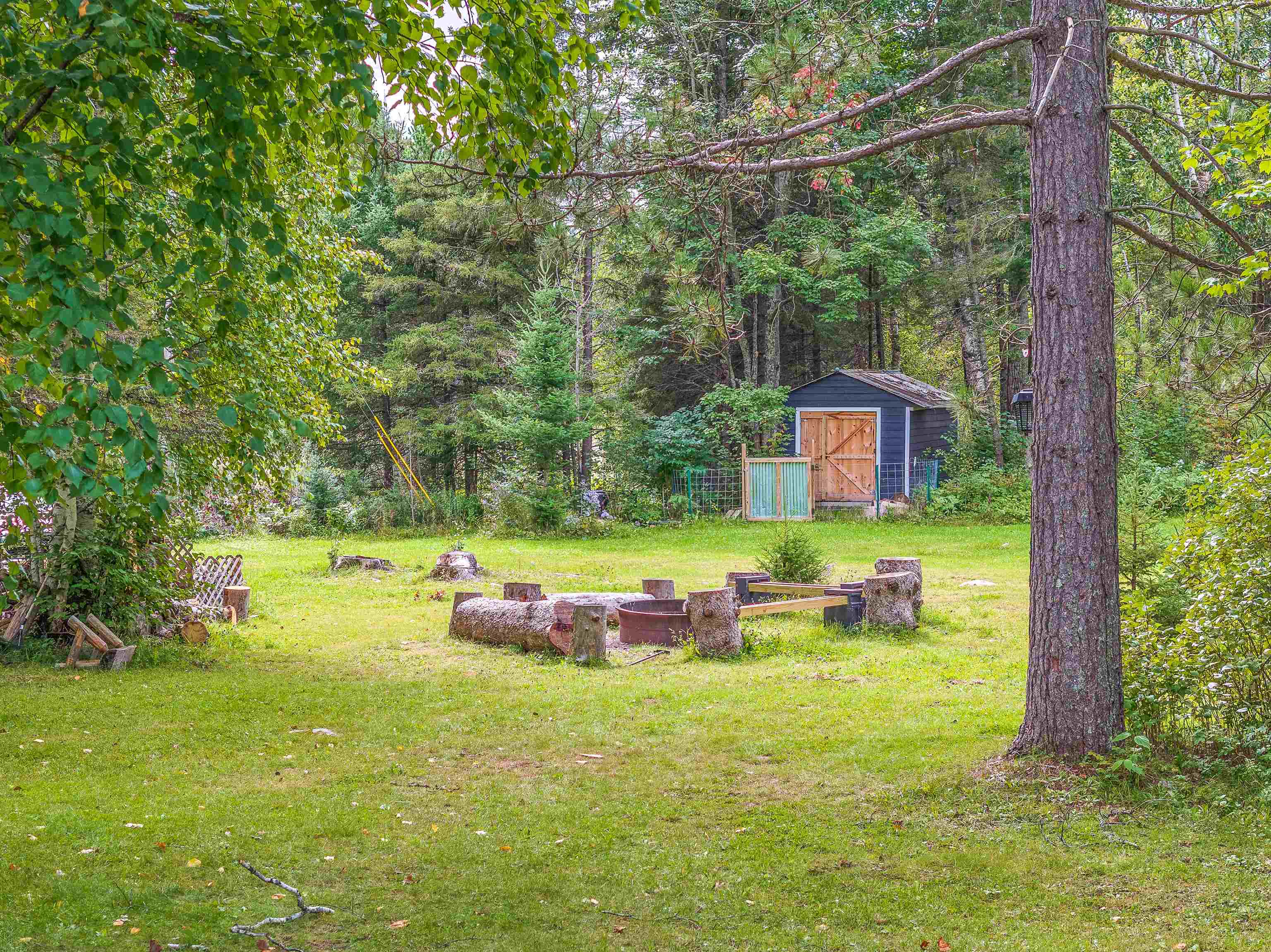 7345 Rahkola Road Embarrass, MN 55732 - Photo 4 of 57 View of green lawn featuring a fire pit and a storage unit
