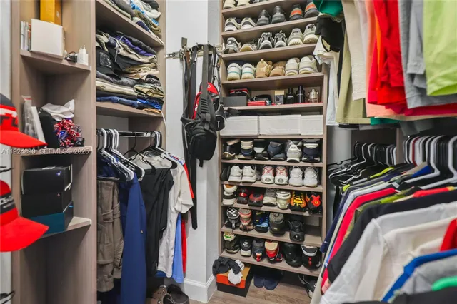 a view of walk in closet with clothes and shoes