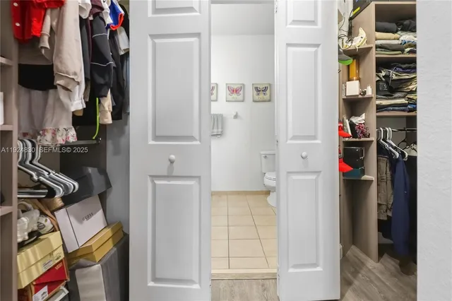 a view of walk in closet with clothes and shoes