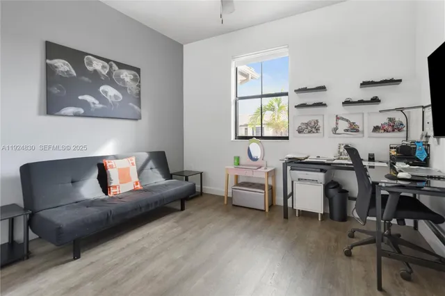 a living room with furniture a desk and chair with wooden floor
